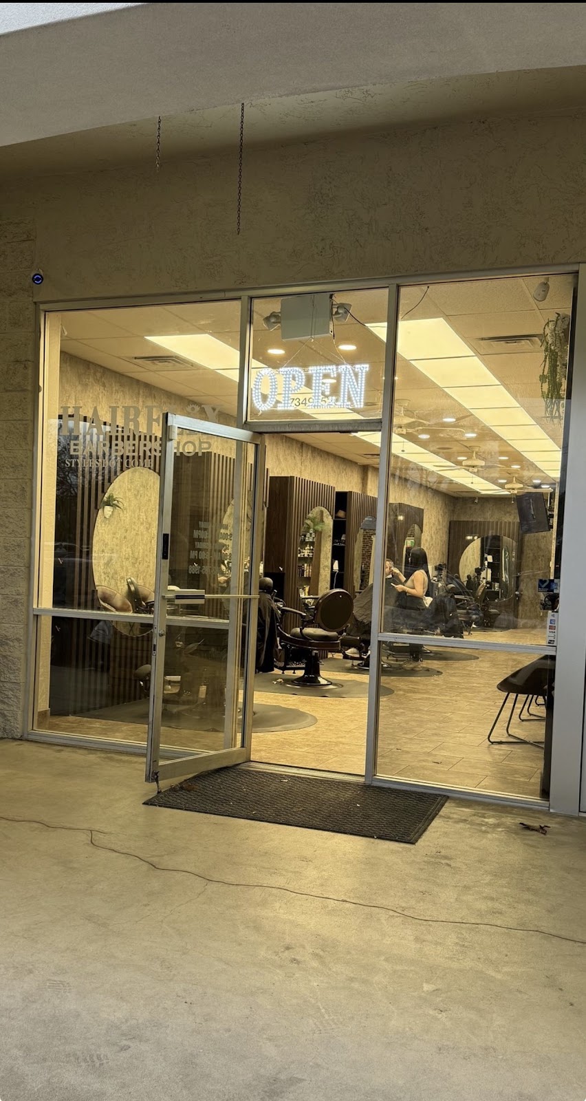 Our glass doors at Paseo Village with the open sign lit at dusk